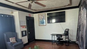 A room with a ceiling fan, a black door, a framed picture, a desk with a chair, and a plant on a table. - Step into this spacious-style home (Milwaukee)