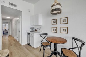 Una cucina moderna con mobili bianchi, un tavolo da pranzo in legno e sedie nere.