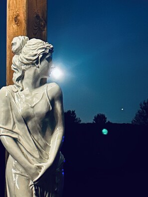 A statue of a woman with a light source behind her, creating a silhouette effect. - Coastal Charm Meets Country Calm | Relaxing Cottage with Water Views & Hot Tub (Cocagne)