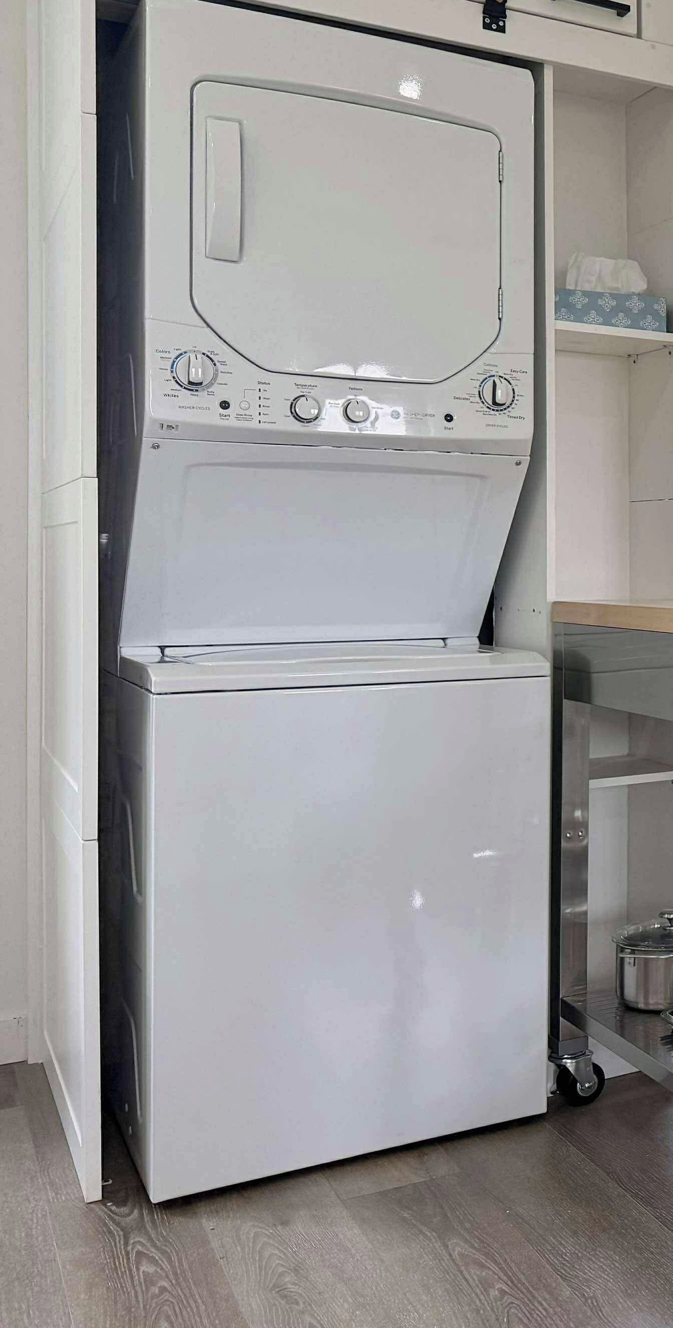 A compact, white, wall-mounted washer and dryer unit with a control panel featuring multiple settings.