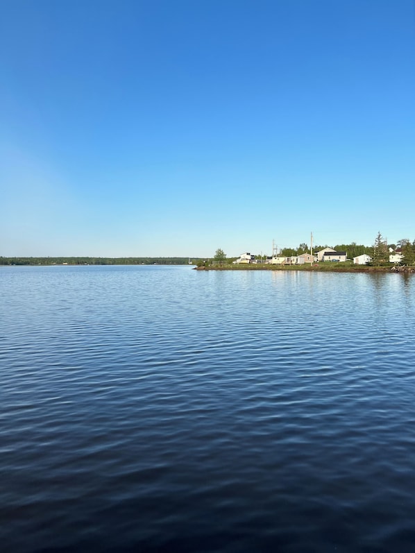 A calm lake with a small island in the distance. - Coastal Charm Meets Country Calm | Relaxing Cottage with Water Views & Hot Tub (Cocagne)