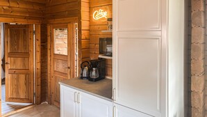 A wooden interior with a neon coffee sign, a kettle, and a microwave on a countertop. - 3 bedroom beautiful home in Haderslev (Haderslev)