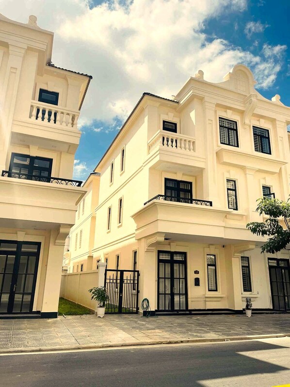A multi-story building with a symmetrical facade, large windows, and a gated entrance.