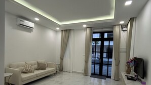 Una sala de estar moderna con un sofá, un televisor y un suelo de mármol.