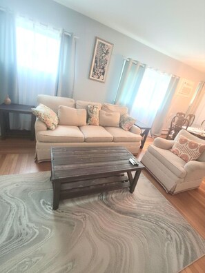 Un salon avec un canapé, une table basse et un tapis à motifs.