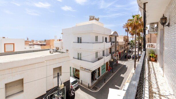 A multi-story building with balconies, a street view, and a clear sky. - Holiday Home 'Mirador De Sorbas' with Balcony and Air Conditioning (Carboneras)