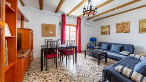 A room with a dining table, chairs, a sofa, a chandelier, and artwork on the walls. - Holiday Home 'Mirador De Sorbas' with Balcony and Air Conditioning (Carboneras)