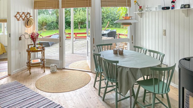 A dining area with a round table and chairs, a buffet table with dishes, and a view of a garden through glass doors. - Awesome home in Humble with WiFi (Humble)