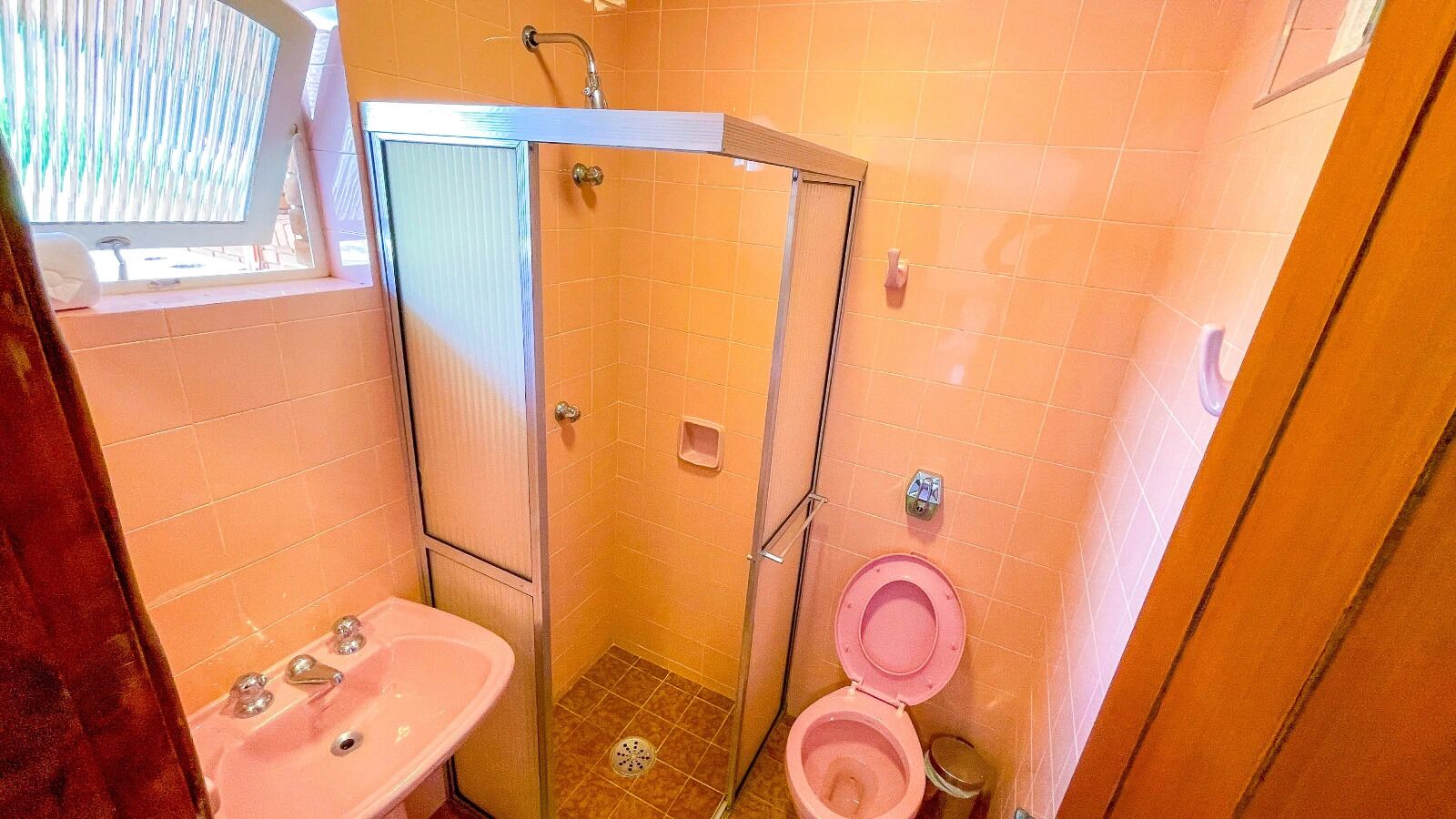 A small bathroom with a shower, a toilet, and a sink.