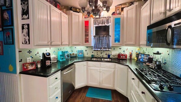 A kitchen with white cabinets, a black stove, and a blue countertop. - Here ye, Here ye! Royal Retreat 5 Minutes to Scarborough Renaissance Festival! (Waxahachie)