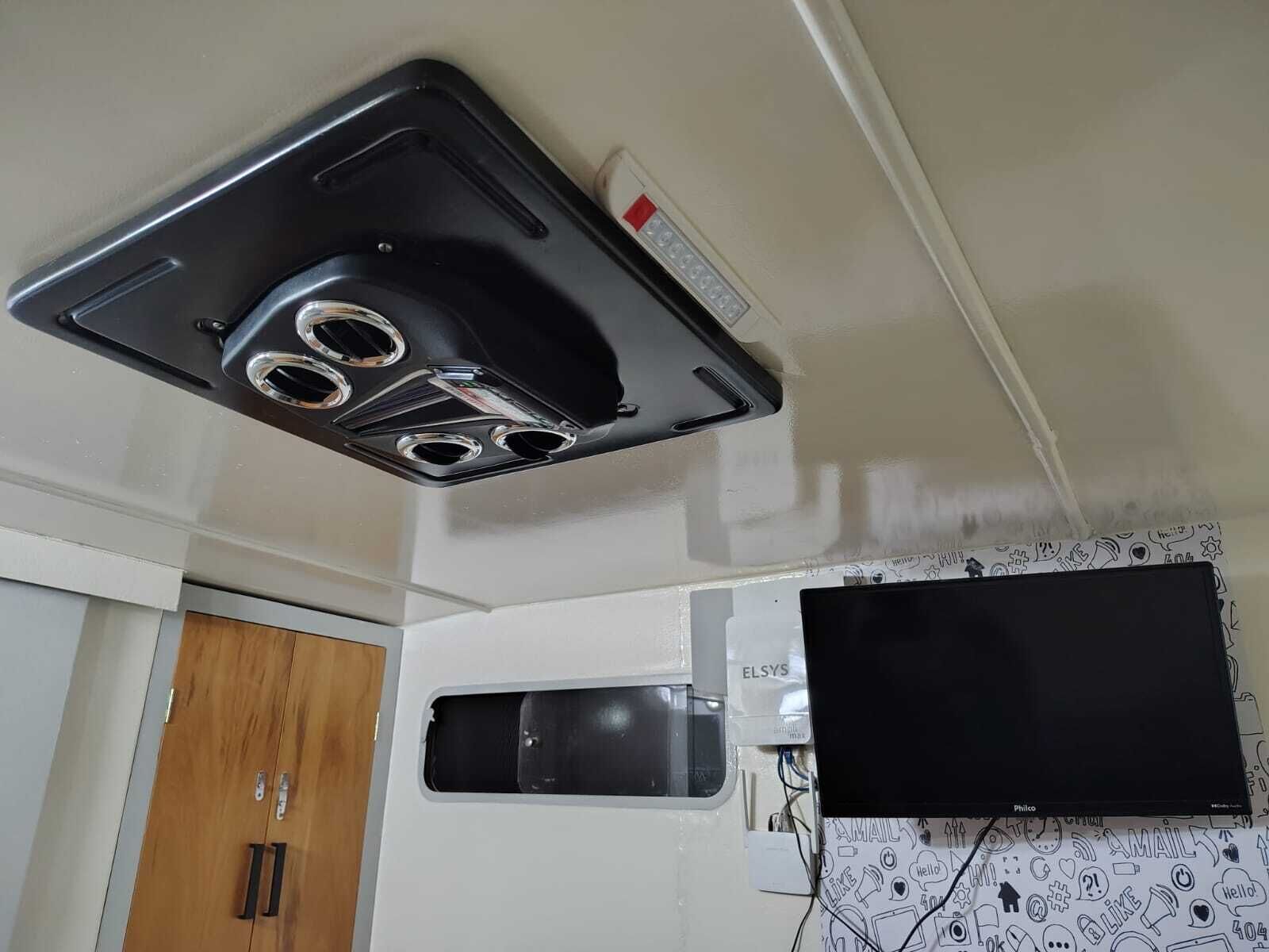 Una kitchenette con una campana extractora negra, un microondas y un armario blanco.