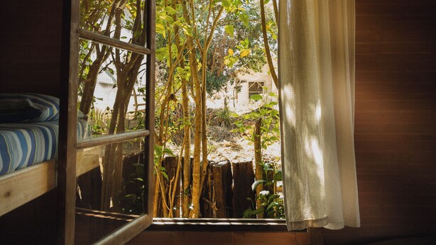 A room with a window, wooden walls, and a bed. - Camping Tiradentes (Tiradentes)
