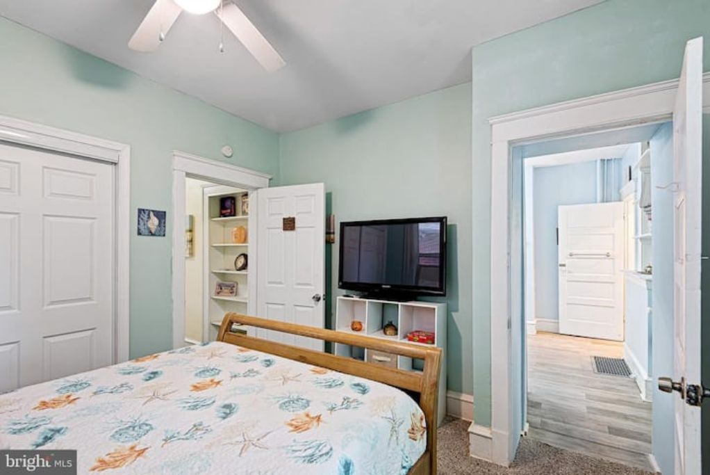 A bedroom with a bed, a television, and a wardrobe.