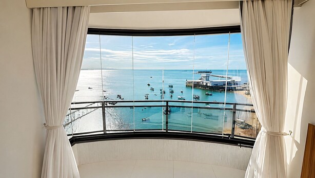A balcony with a view of the sea and boats. - Hosts BR - Flat frente mar (Fortaleza)