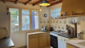 A kitchen with wooden cabinets, a gas stove, a dishwasher, and a window with a view of the outside.