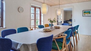 A dining area with a long table, blue chairs, and hanging pendant lights. - Pet friendly home in Sønder Felding with WiFi (Sønder Felding)
