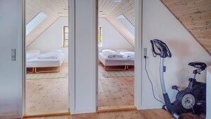 A room with two beds, a ceiling fan, and a stationary exercise bike. - Pet friendly home in Sønder Felding with WiFi (Sønder Felding)