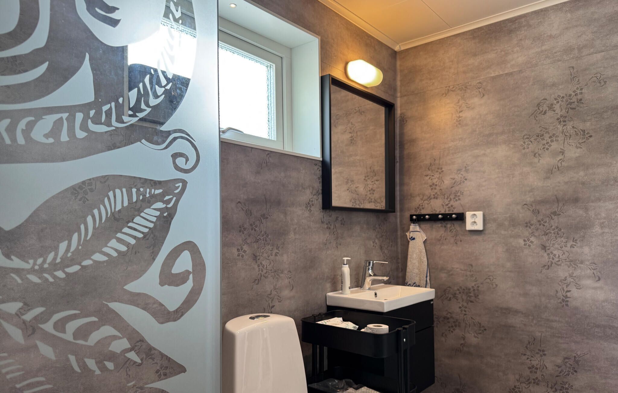 Een badkamer met een wastafel, spiegel en handdoekrek.