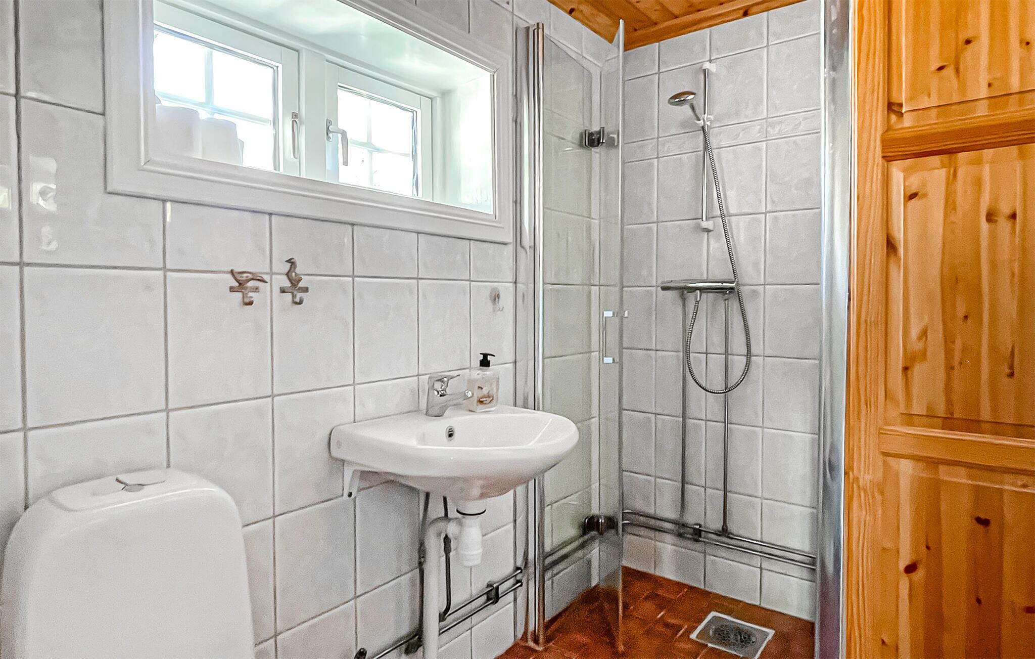 A bathroom with a white sink, a toilet, and a shower.