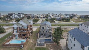 Un quartier résidentiel composé de plusieurs maisons à deux étages, doté d’une piscine et offrant une vue sur l’océan.