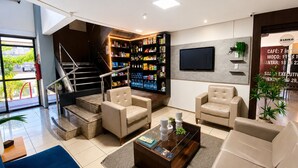 Un vestíbulo con una escalera, zona de estar y un bar con estanterías.