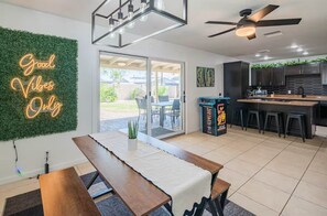 A modern kitchen with a bar area, a neon sign, and a view of the outdoors. - Charming 3-bedroom house in awesome Scottsdale (Scottsdale)
