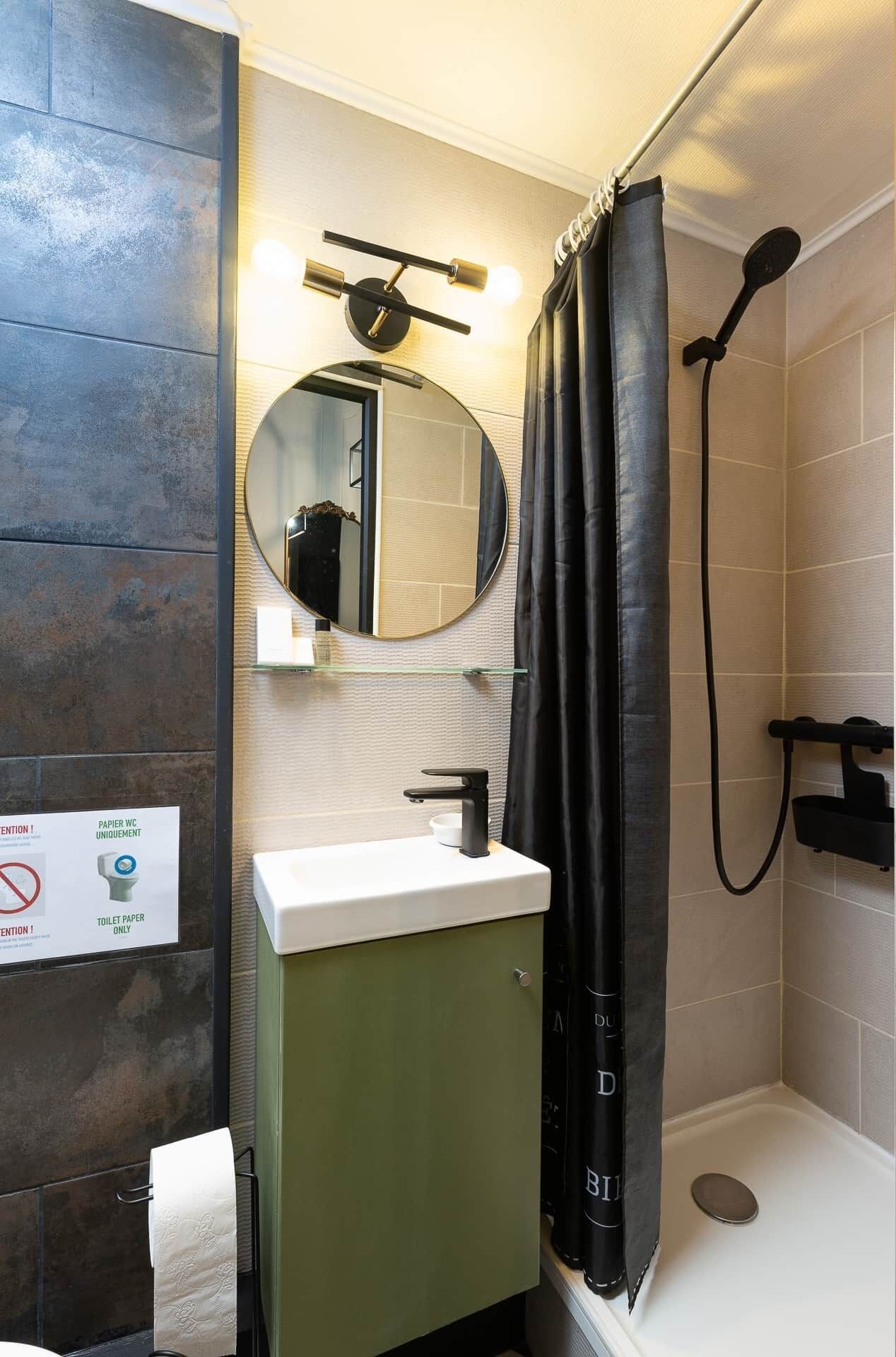 Un baño con lavamanos, espejo y ducha.