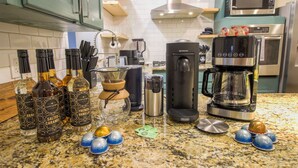 Un comptoir de cuisine avec du matériel pour préparer le café, des salières et des poivrières, et des objets décoratifs.