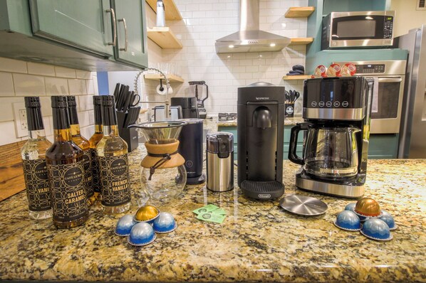 A kitchen counter with coffee-making equipment, salt and pepper shakers, and decorative items. - Heated Pool - Pickleball - Putting Green (Savannah)