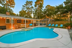 A backyard with a swimming pool, outdoor seating, and a sign for Netflix.