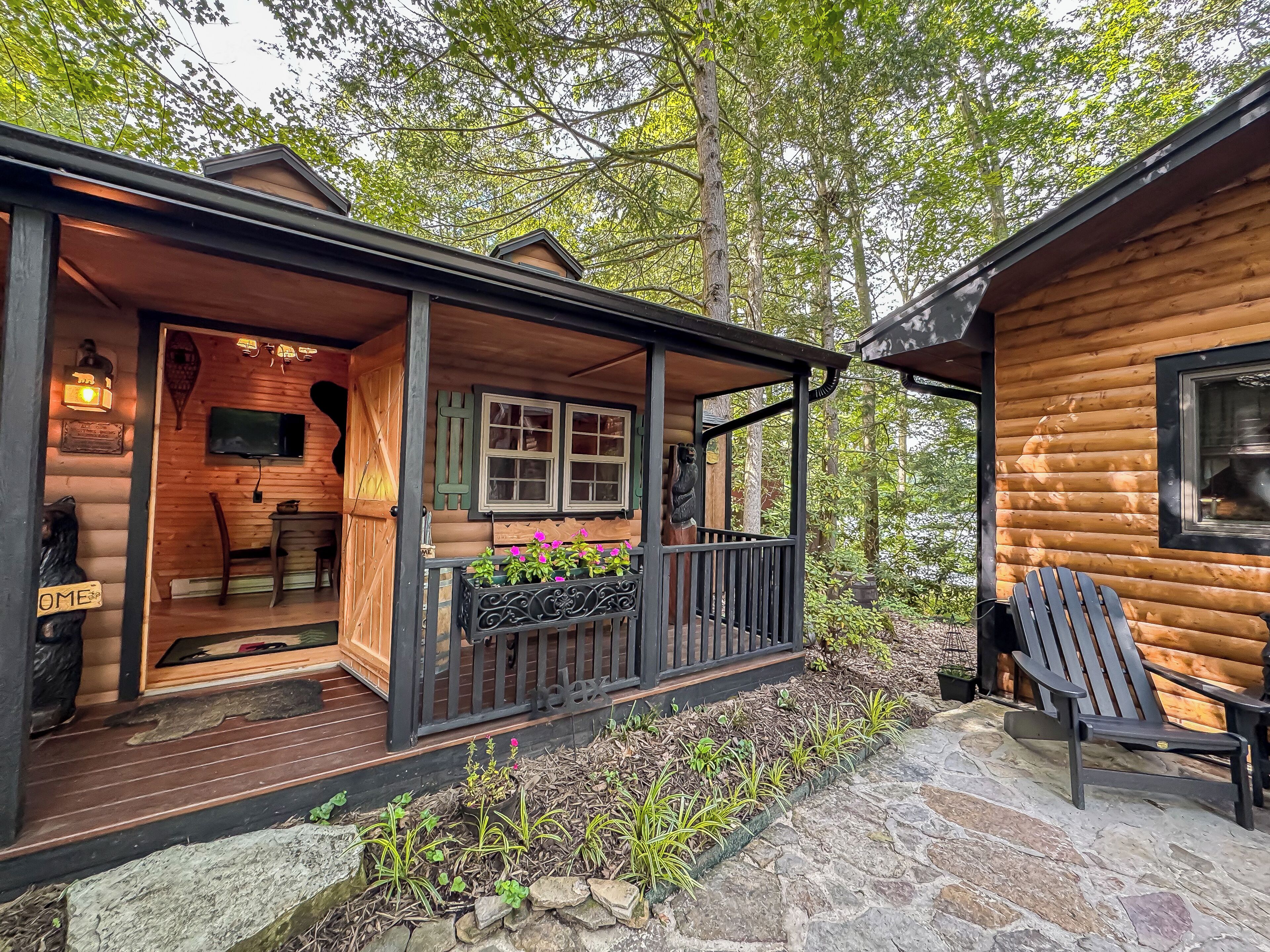 Eine Blockhütte mit Veranda, einem Essbereich und einem Kiesweg.