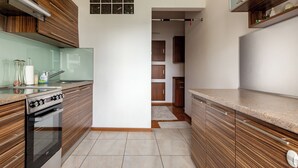 Een moderne keuken met houten kastjes, een inbouwoven en een aanrecht.