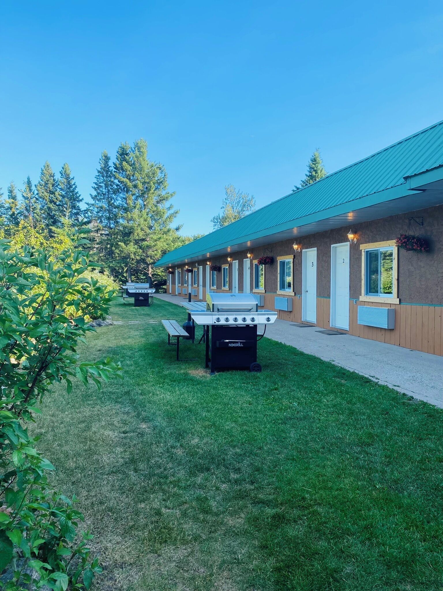 Un motel doté d’un toit végétalisé, d’un espace extérieur aménagé pour s’asseoir et d’un coin barbecue.