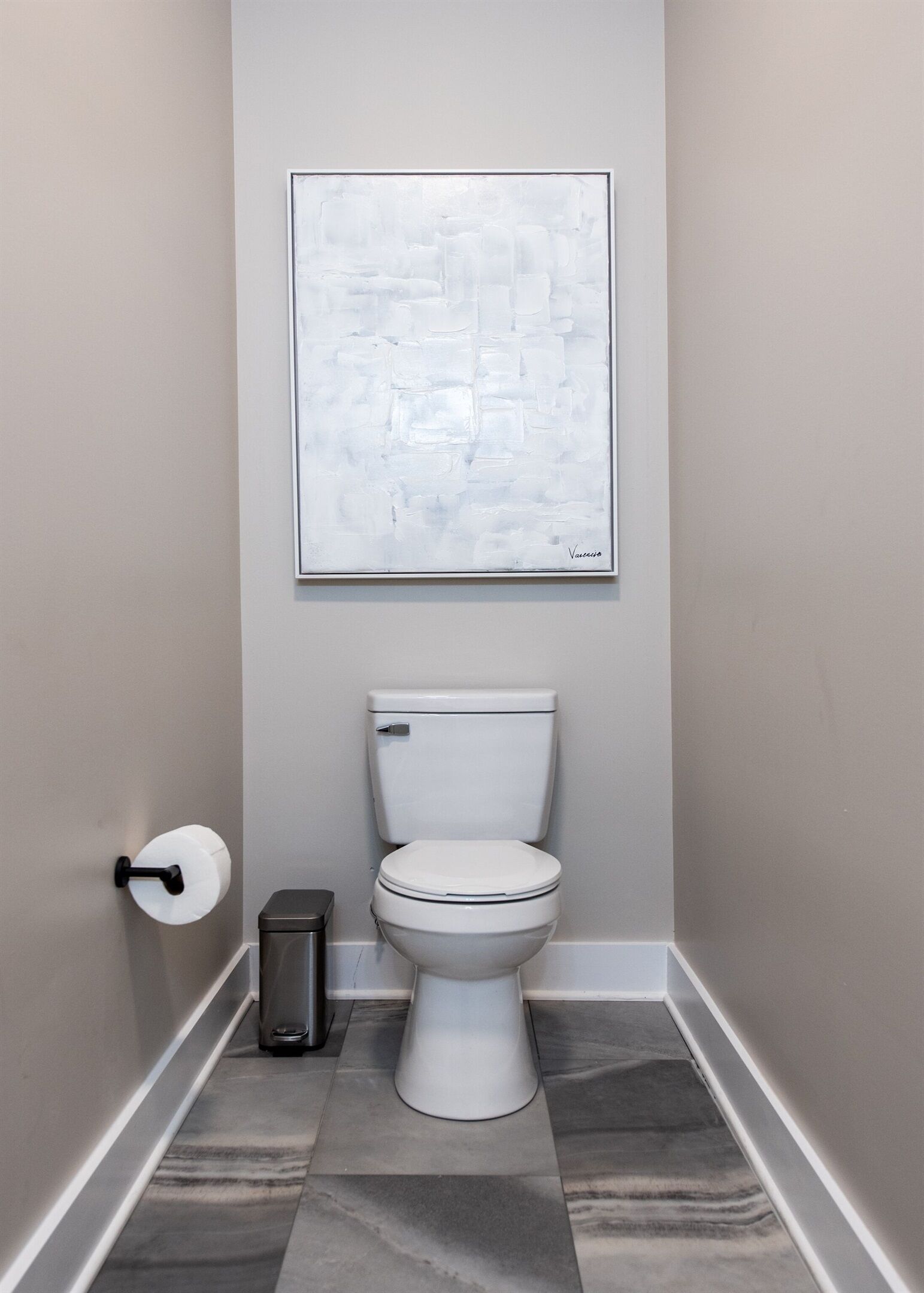 Ein Badezimmer mit Toilette, Toilettenpapier und Mülleimer.