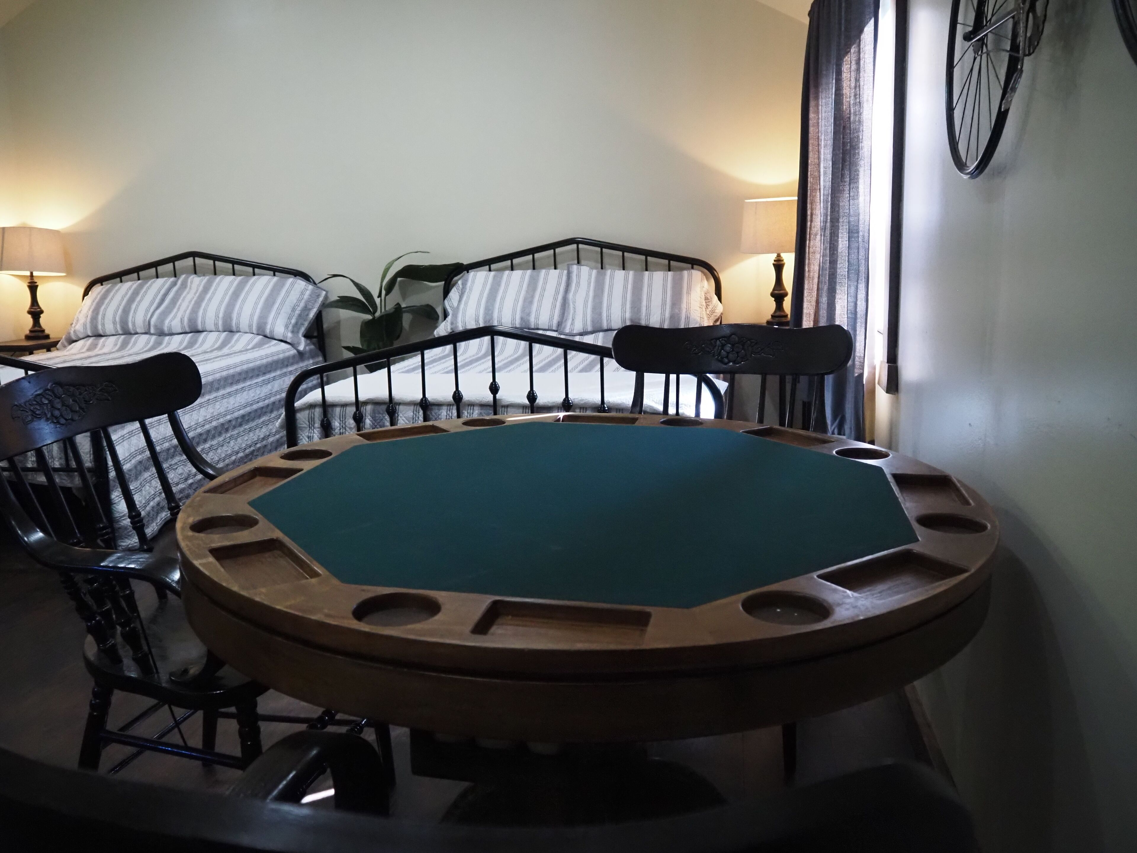 Una habitación con dos camas, una mesa redonda y una silla.