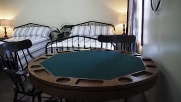 Una habitación con dos camas, una mesa redonda y una silla.