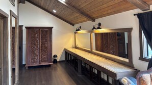 Um quarto com teto de madeira, uma mesa comprida e um espelho grande.