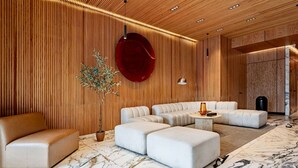 Et moderne interiør med en modulsofa, en potteplante og en rund, rød vægdekoration.