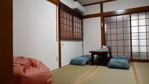 A traditional Japanese room with tatami flooring, a low wooden table, and a sliding door with a grid pattern. - GINTAKEI (Osaka)