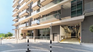 Un hotel moderno de varios pisos con una entrada destacada, un área de estar al aire libre y una fachada bien conservada.