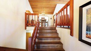 A wooden staircase with a railing, leading to a dining area with a table and chairs. - Alpine 4 - SHARC, Hot Tub, A/C, Light & Bright! (Sunriver)