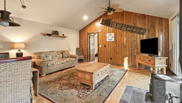 A spacious living room with a wooden ceiling, a large sofa, a coffee table, and a television. - Augusta 3 - Private Heated Pool - Sweeping Golf Course Views - Separate Apartment (Sunriver)