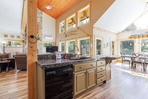 A spacious kitchen with a granite countertop, wooden cabinets, and a dishwasher.