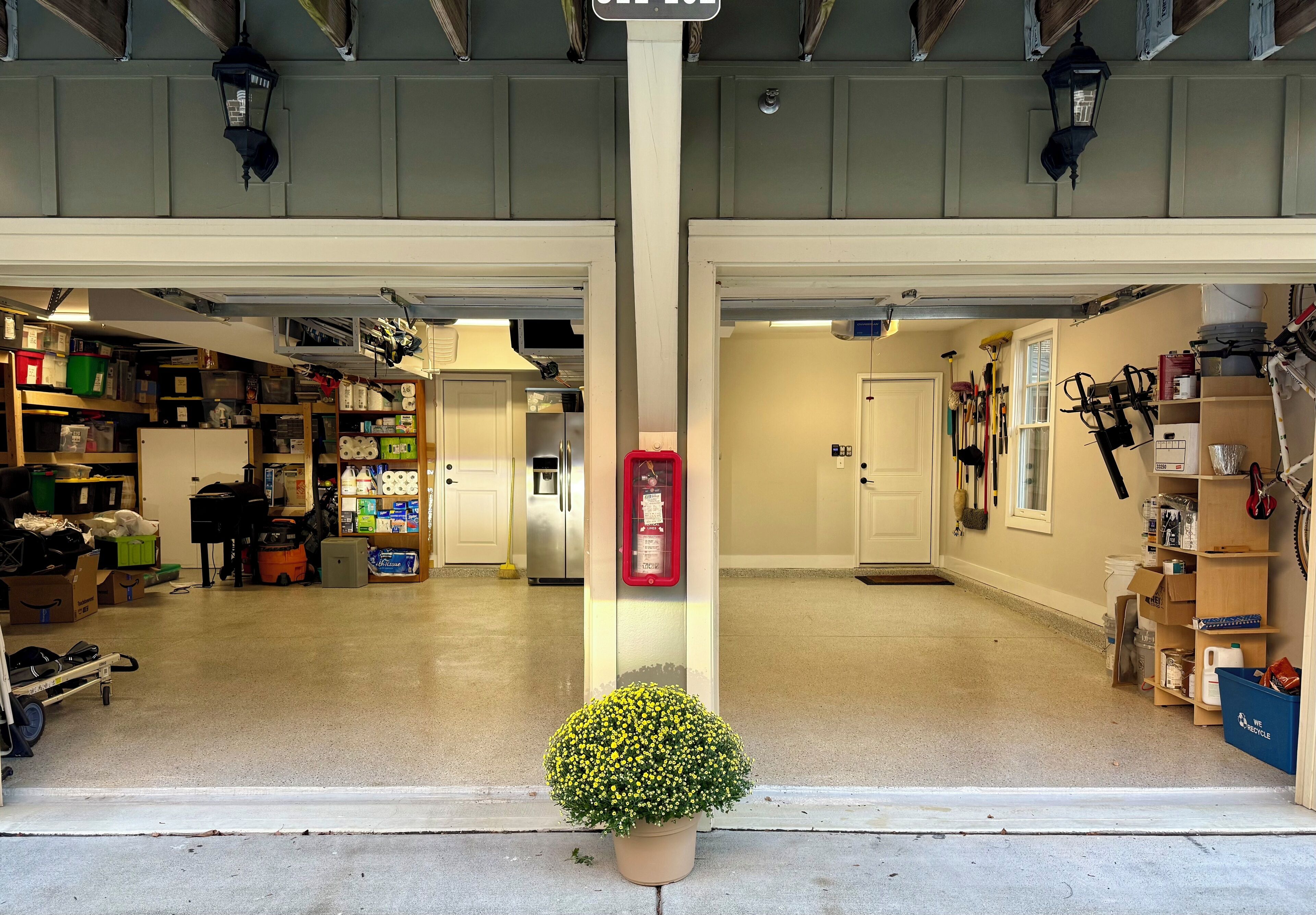 A garage with storage shelves, a fire extinguisher, and a potted plant.