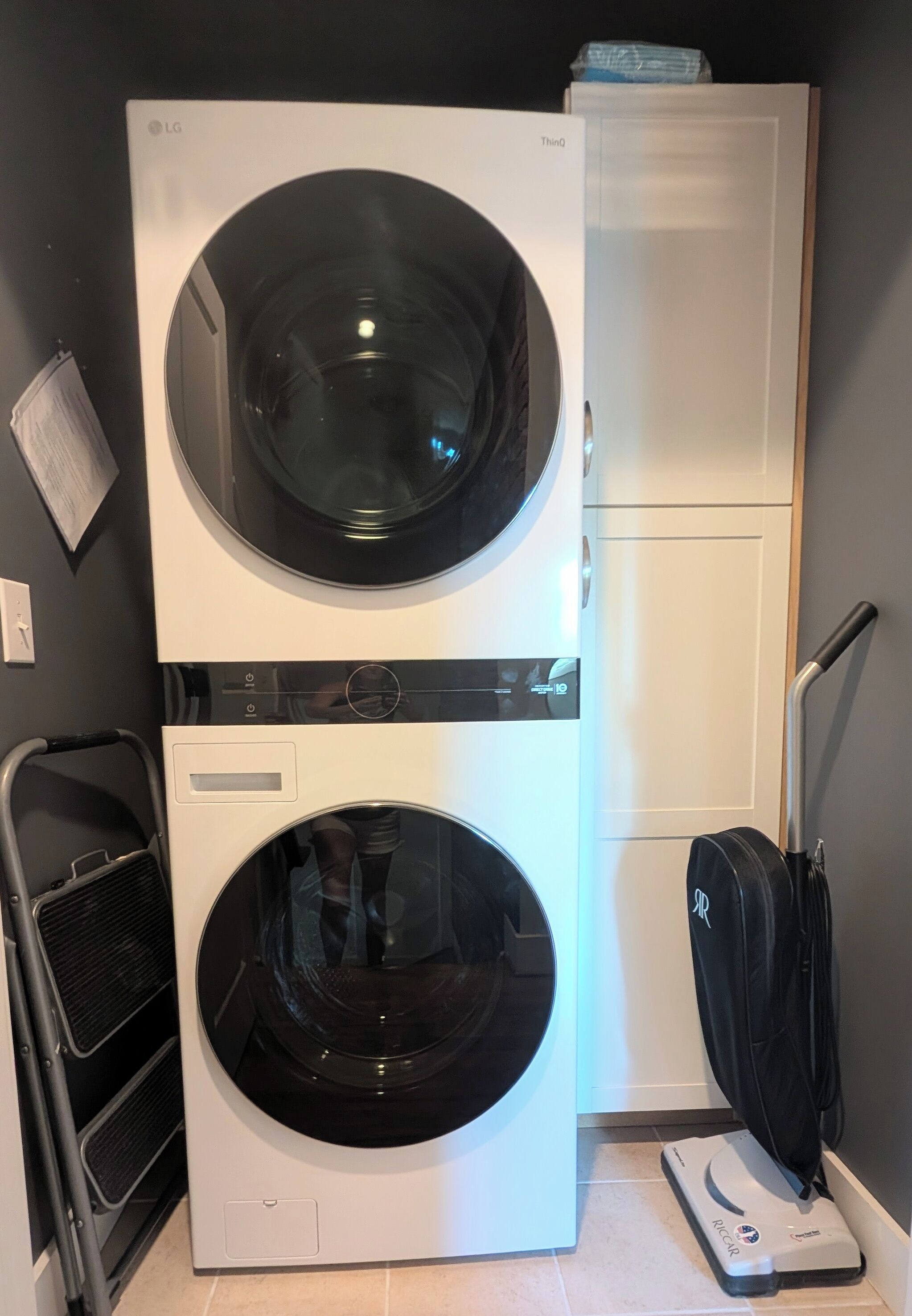Une machine à laver et un sèche-linge superposés dans une buanderie.