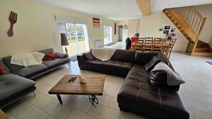 A living room with a sectional sofa, a coffee table, and a staircase.
