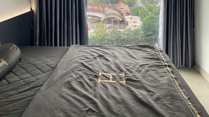 Een slaapkamer met een groot raam, een bed en een airconditioning.