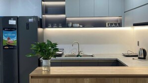 Een moderne keuken met een centraal eiland, inbouwapparatuur en verlichting onder de keukenkastjes.