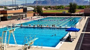 A swimming pool with diving platforms, a spectator area, and a mountainous backdrop. - Spacious 2BR Condo by Downtown Mesa Free Parking (Mesa)