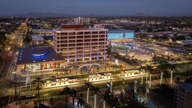 A multi-story hotel with a circular atrium, a parking lot, and a view of the surrounding cityscape. - Spacious 2BR Condo by Downtown Mesa Free Parking (Mesa)